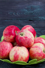 Apples in a vase. On brushed black-green boards.