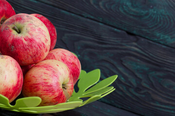Apples in a vase. On brushed black-green boards.