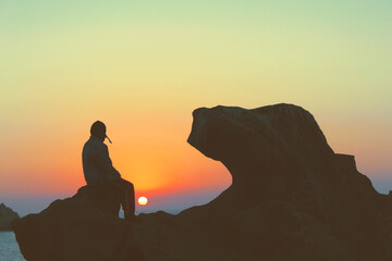 silhouette of a person on a rock