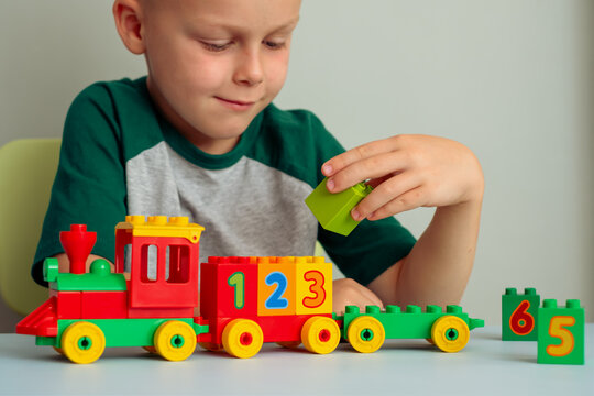 Child playing with a train, blocks of numbers. Educational toys for preschool and kindergarten children.