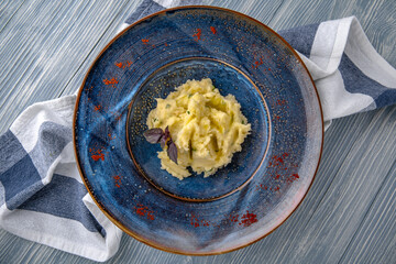 Mashed potatoes with olive oil. Natural delicious food. Greek cuisine menu. Still life in a marine style on a blue background.