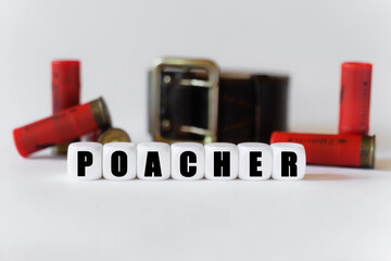 Against the background of cartridges and a military belt, cubes with the inscription - POACHER