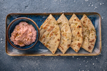 Cheese cream snack with smoked salmon with pita bread. Natural delicious food. Greek cuisine menu. Still life in a marine style on a blue background.