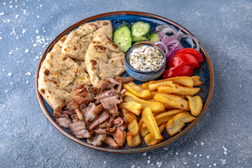 Pita shawarma with olive oil, meat, potatoes and vegetables. Natural delicious food. Greek cuisine menu. Still life in a marine style on a blue background.