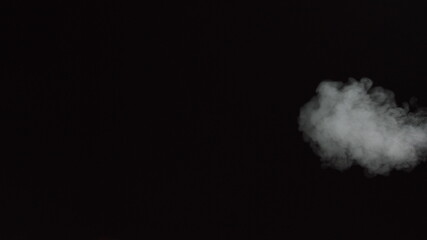White water vapour on a black background. Close-up shot. White Fume Slowly Floating Rises Up. Abstract Haze Cloud. Animation Mist Effect. Smoke Stream Effect 4K