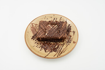 White chocolate brownie slice on plate over white background