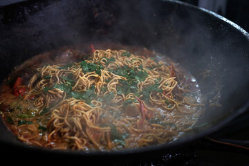 Vendor Cooking Mie Goreng Kepiting, Fried Seafood Noodle curry with crab in a pan