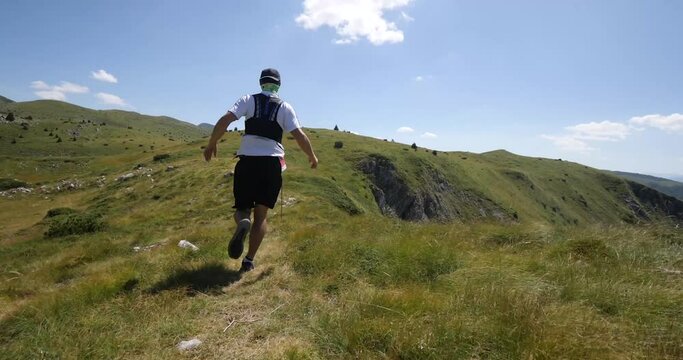 Trail running man on the ridge running in slow motion. 