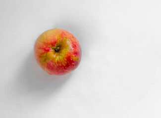 red  and yellow  fresh wet apple on the white table close up  view from the top
