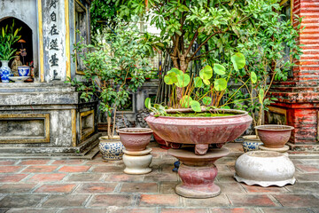 Fototapeta na wymiar Flowers and sculptures at the one pillar pagoda in Hanoi Vietnam