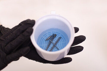 Sterilization and disinfection of manicure tools and nail instrument in white container with...