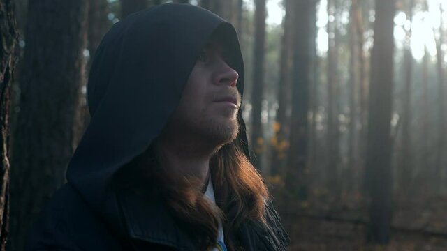 Mysterious Pilgrim Wanderer in Black Cowl Coat Stands Thinking in Misty Autumn Forest. 2x Slow motion 60 FPS