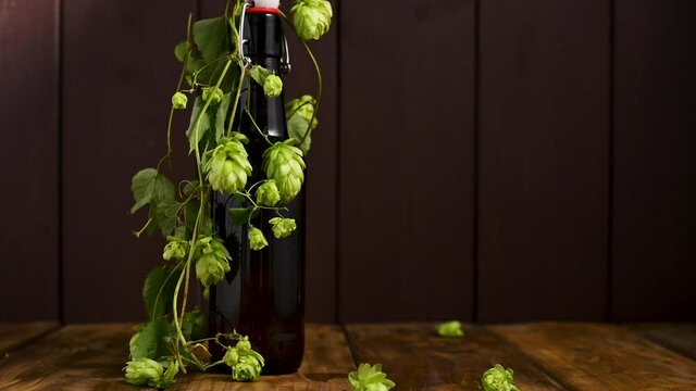 Beer. Cold Craft light Beer in a glass with water drops. Pint of Beer close up on a wooden background. Beer is pouring from the bottle. Border design. High quality 4k footage