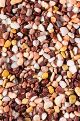 Multi-colored small river stones texture and background.
