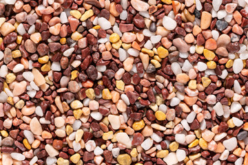 Multi-colored small river stones texture and background.