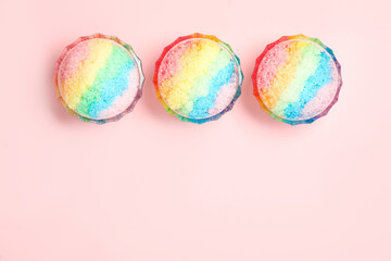 Rainbow shaving ice in glass dessert bowls on light background, flat lay. Space for text