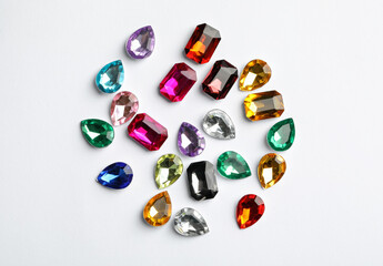Different beautiful gemstones on white background, top view