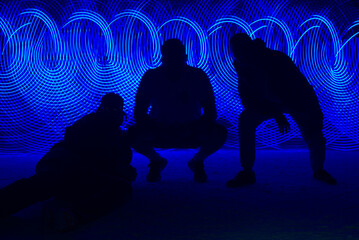 Blue Light Spirals and Silhouettes of Three People