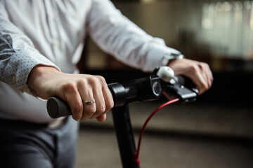 Close Up photo shoot of man hands on the electro scooter steering wheel