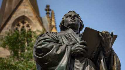 Statue of German reformer Martin Luther in front of Kaufmannskirche (Merchant's Church) in Erfurt, Germany - obrazy, fototapety, plakaty