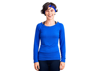 Beautiful young woman with short hair wearing training workout clothes winking looking at the camera with sexy expression, cheerful and happy face.