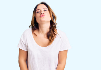 Fototapeta premium Young beautiful caucasian woman wearing casual white tshirt looking at the camera blowing a kiss on air being lovely and sexy. love expression.