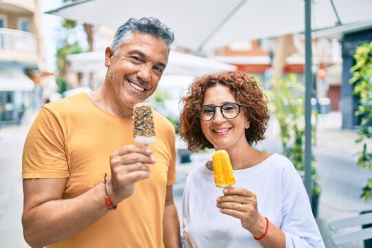 Middle Age Couple Smiling Happy Eating Ice Cream At Street Of City.