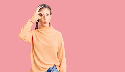 Fototapeta premium Beautiful caucasian woman with blonde hair wearing casual winter sweater doing ok gesture shocked with surprised face, eye looking through fingers. unbelieving expression.