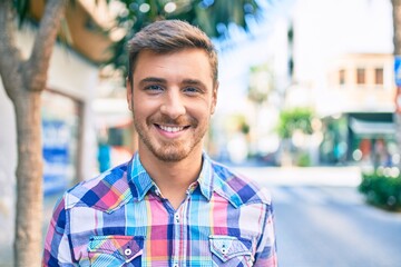 Young caucasian man smiling happy walking at the city.