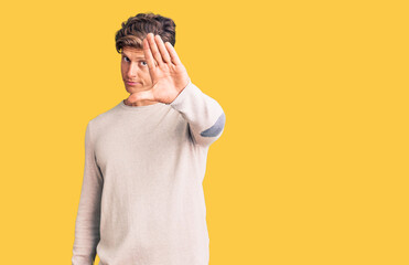 Young handsome man wearing casual clothes doing stop sing with palm of the hand. warning expression...