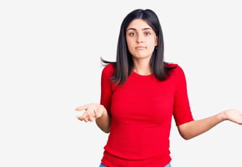 Young beautiful girl wearing casual t shirt clueless and confused expression with arms and hands raised. doubt concept.