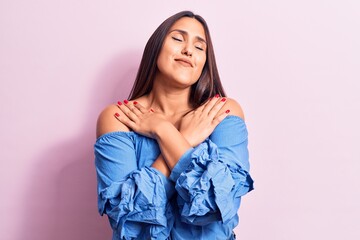 Young beautiful brunette woman wearing casual t-shirt hugging oneself happy and positive, smiling confident. self love and self care