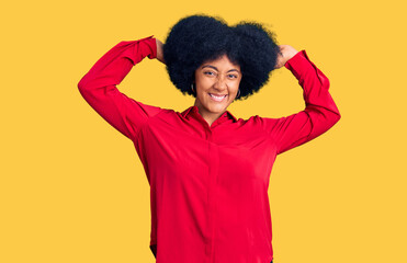 Fototapeta na wymiar Young african american girl wearing casual clothes relaxing and stretching, arms and hands behind head and neck smiling happy