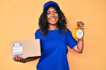 Young african american woman holding delivery package and alarm clock smiling with a happy and cool smile on face. showing teeth.