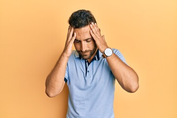 Handsome man with beard wearing casual clothes with hand on head for pain in head because stress. suffering migraine.