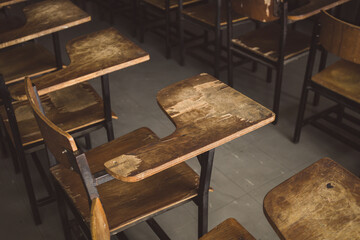 old wooden row lecture chairs in dirty classroom in poor school.study room without student.concept for education in third world ,donate and charity