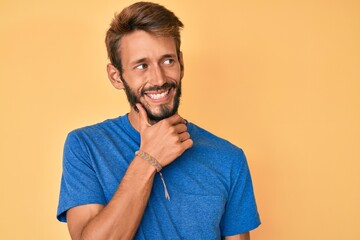 Handsome caucasian man with beard wearing casual clothes with hand on chin thinking about question, pensive expression. smiling with thoughtful face. doubt concept.