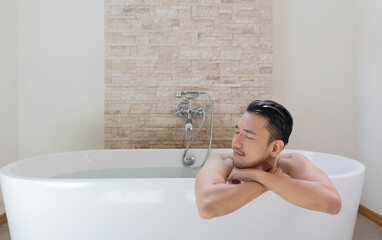 young asian man relax and spa in bathtub.