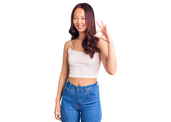 Fototapeta premium Young beautiful chinese girl wearing casual clothes smiling positive doing ok sign with hand and fingers. successful expression.