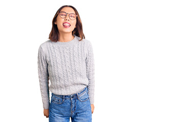 Fototapeta premium Young beautiful chinese girl wearing casual clothes sticking tongue out happy with funny expression. emotion concept.