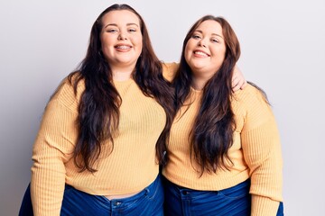 Young plus size twins wearing casual clothes with a happy and cool smile on face. lucky person.