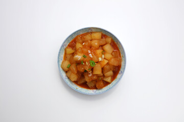 A dish of braised white gourd on a white background board