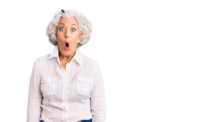 Senior grey-haired woman wearing casual clothes afraid and shocked with surprise expression, fear and excited face.
