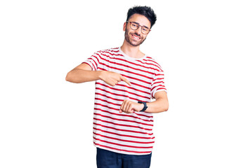 Young hispanic man wearing casual clothes in hurry pointing to watch time, impatience, upset and angry for deadline delay