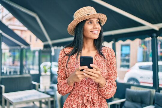 Young african american tourist woman on vacation smiling happy using smartphone at the city.