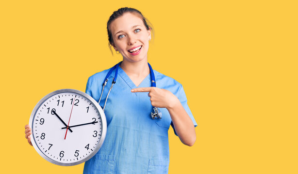 Young beautiful blonde woman wearing doctor uniform and stethoscope smiling happy pointing with hand and finger