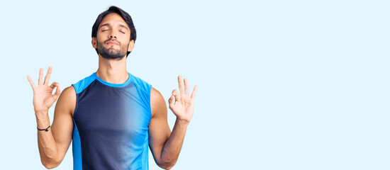 Handsome hispanic man wearing sportswear relax and smiling with eyes closed doing meditation gesture with fingers. yoga concept.