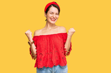 Young brunette woman with short hair wearing casual summer clothes and diadem very happy and excited doing winner gesture with arms raised, smiling and screaming for success. celebration concept.