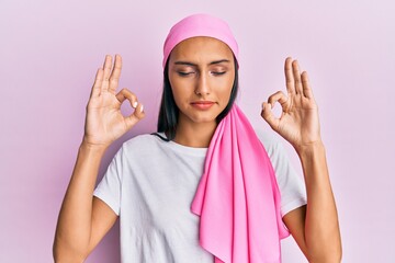 Young brunette woman wearing breast cancer support pink scarf relax and smiling with eyes closed...