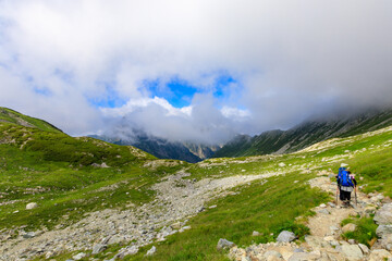雄大な剱の山々と登山道を歩く人